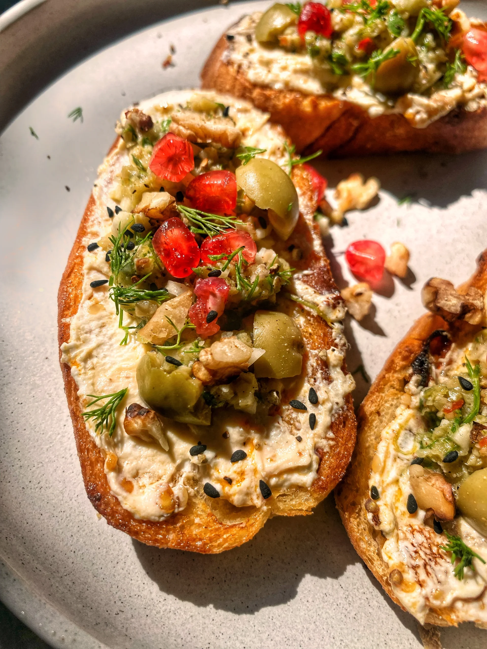 Labneh Toast With Olive Tapenade, Pomegranate and Walnut